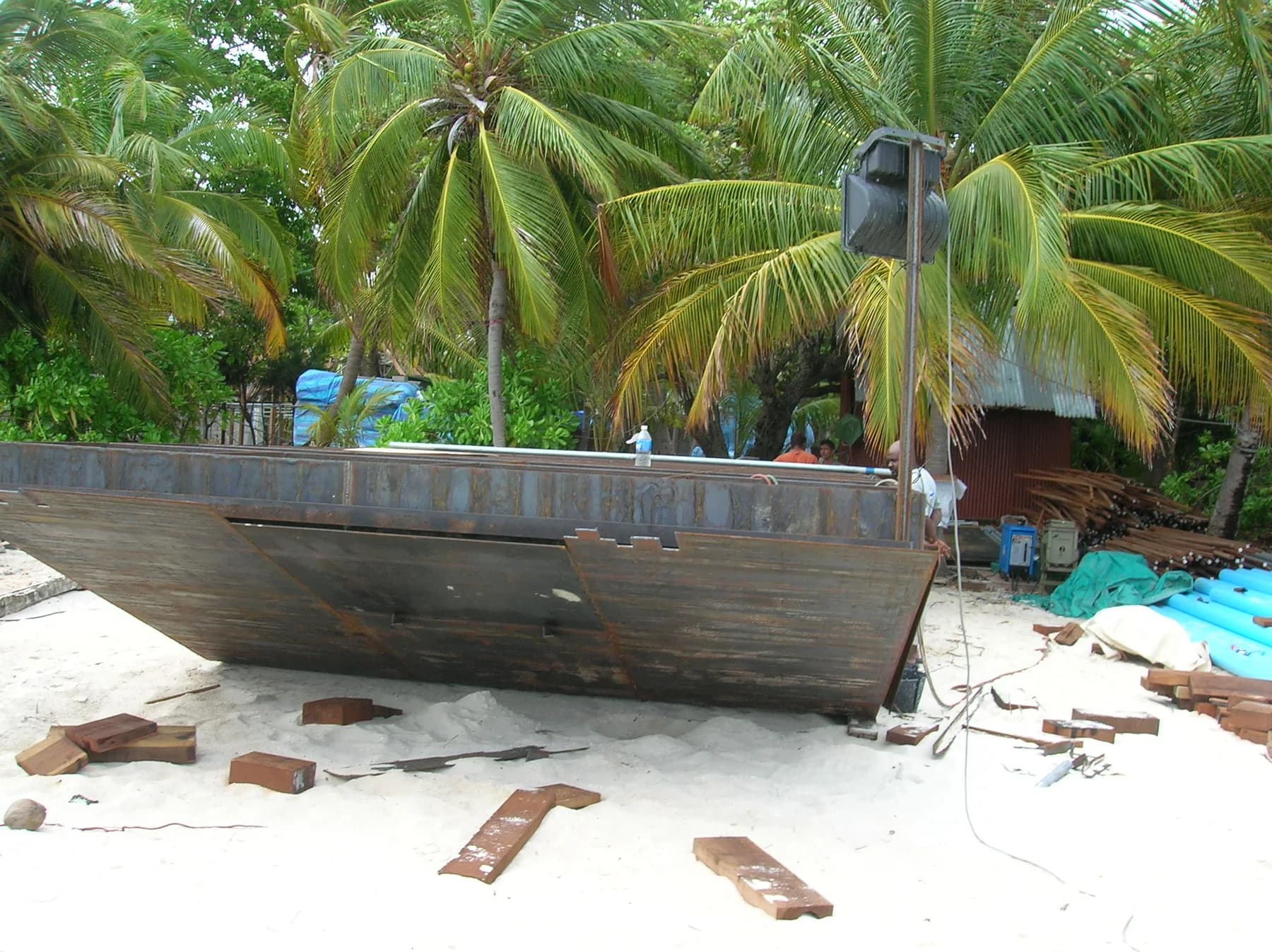 Steel hull of a sand barge under construction on the beach