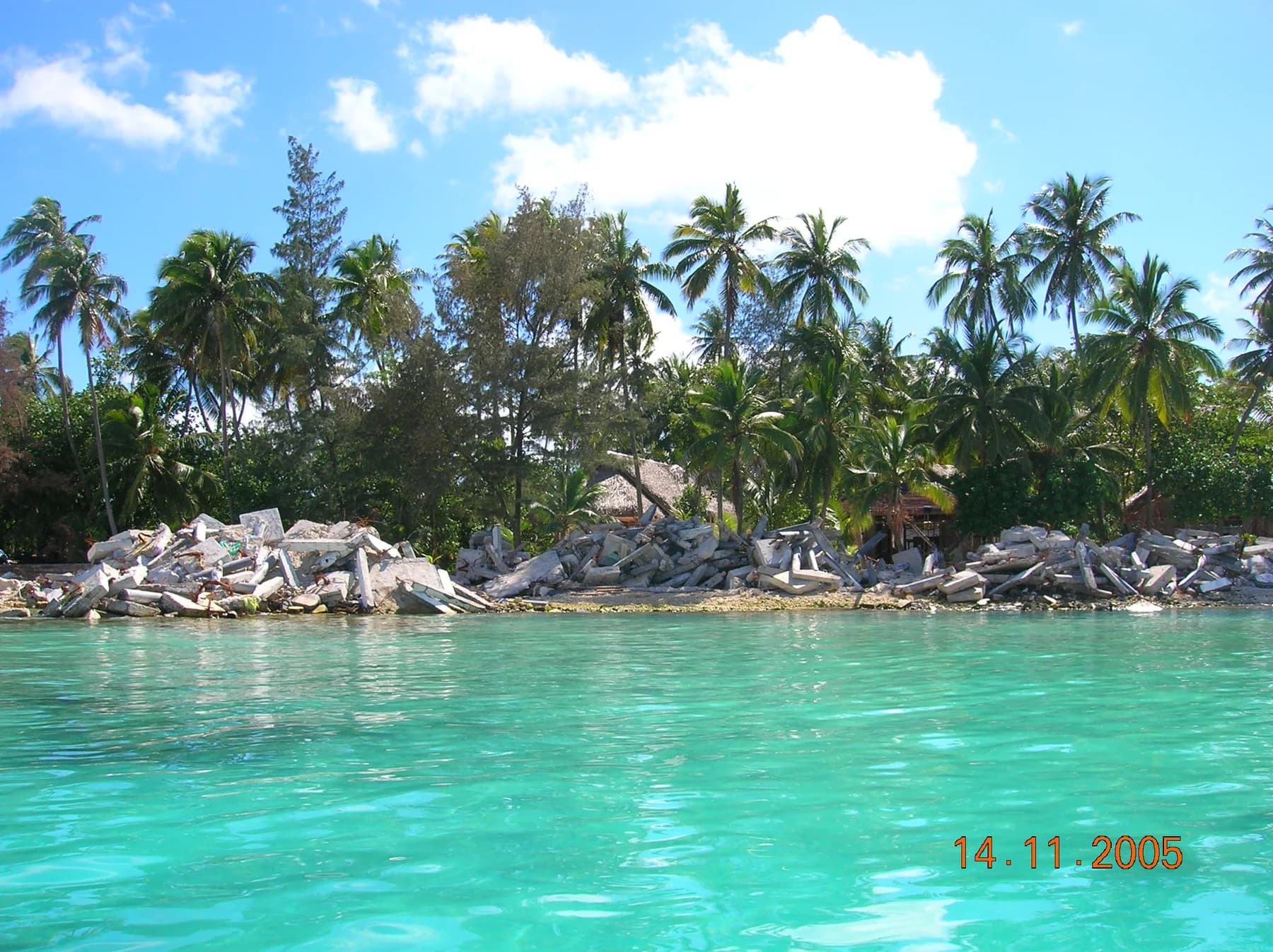 Newly placed shoreline rock armour on a palm-fringed resort beach