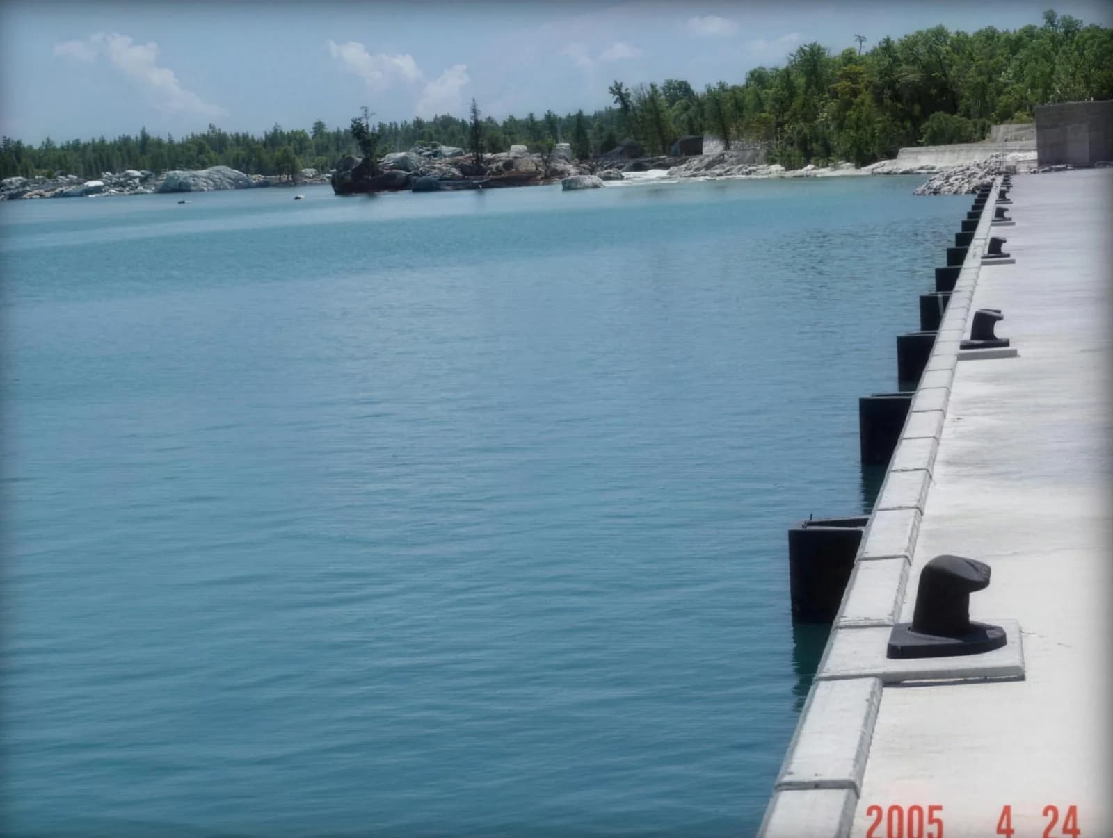 Completed quay wall with mooring bollards along a calm lagoon
